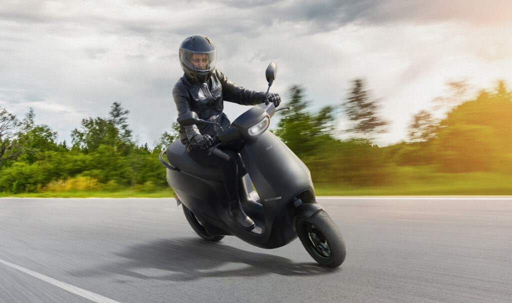 ola s1 black scooter driven by a woman.